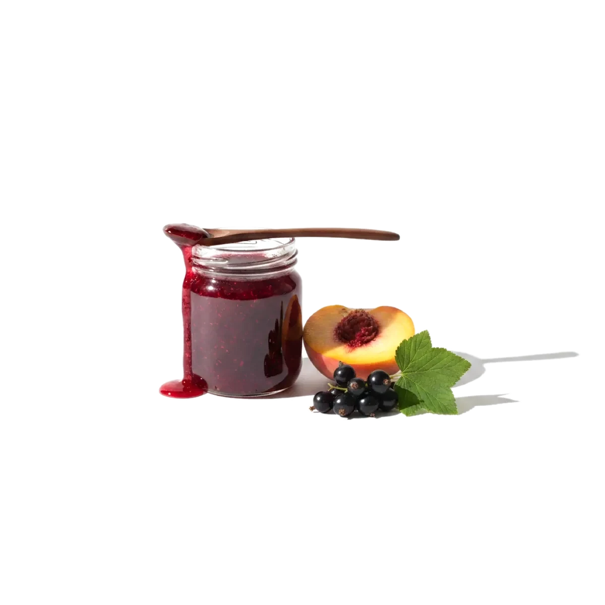 маленькая стеклянная банка с густым тёмно-красным вареньем, рядом половинка персика и веточка чёрной смородины, поперёк банки лежит ложка